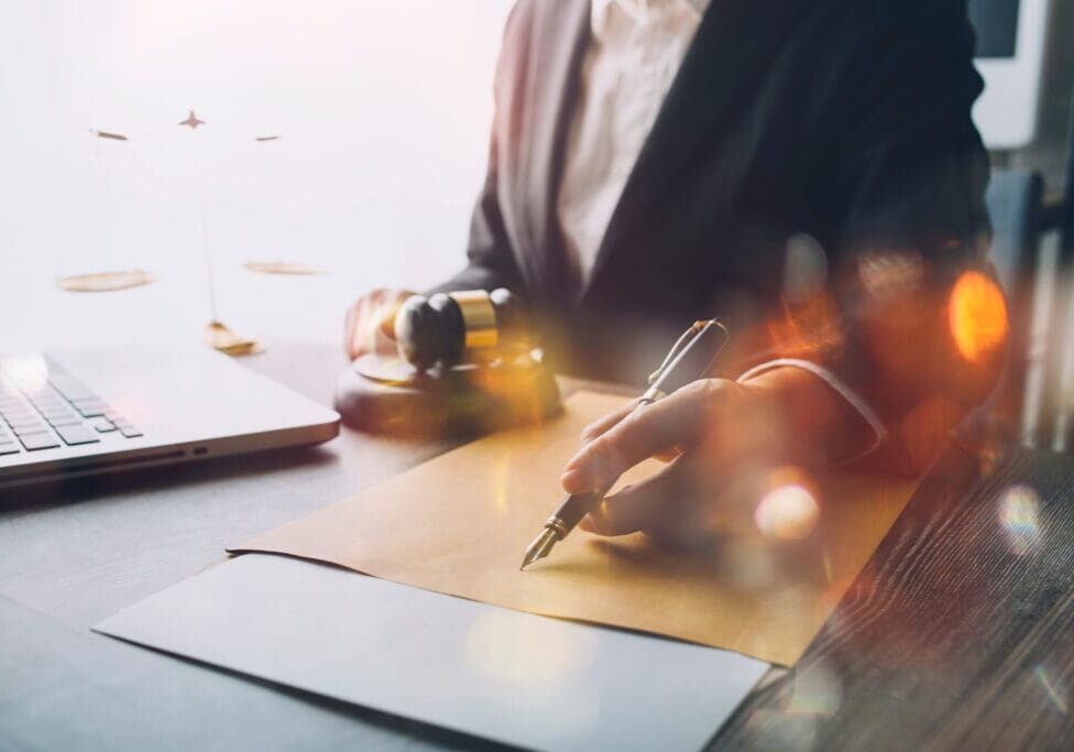 Business and lawyers discussing contract papers with brass scale on desk in office. Law, legal services, advice, justice and law concept picture with film grain effect